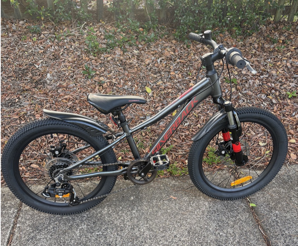A grey and red kids' mountain bike, one of the bikes in the Kingscliff hire fleet