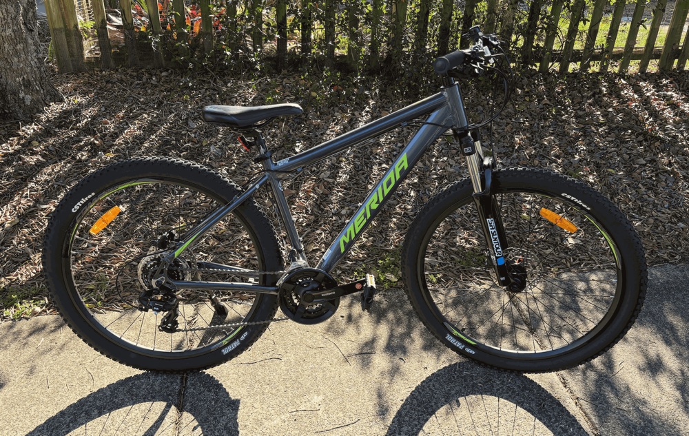 A grey and green adult mountain bike, one of the bikes in the Kingscliff hire fleet